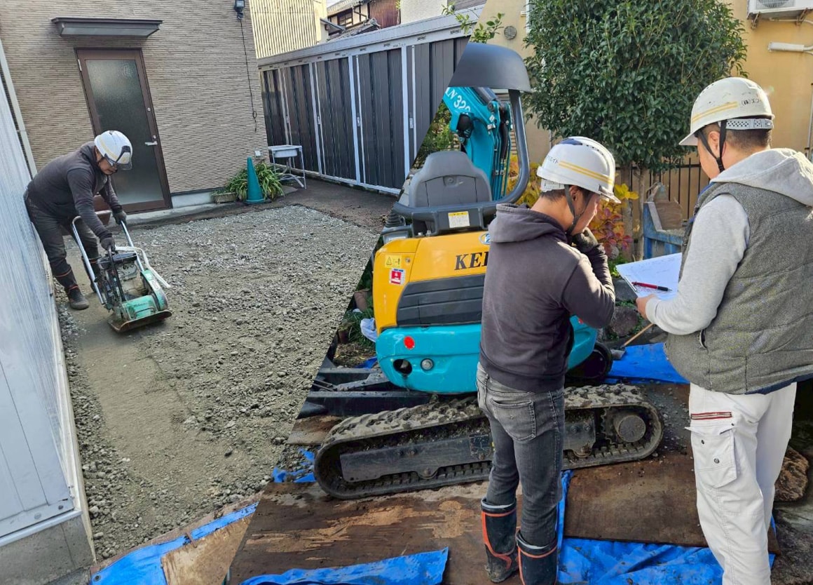 ショベルカーと転圧機を使い、外構の基礎工事を行っているエフ・クリエイトの職人たち